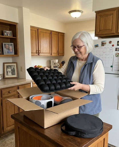 Older woman lifting the black travel cushion from a delivery box with the belt and neck pillow inside